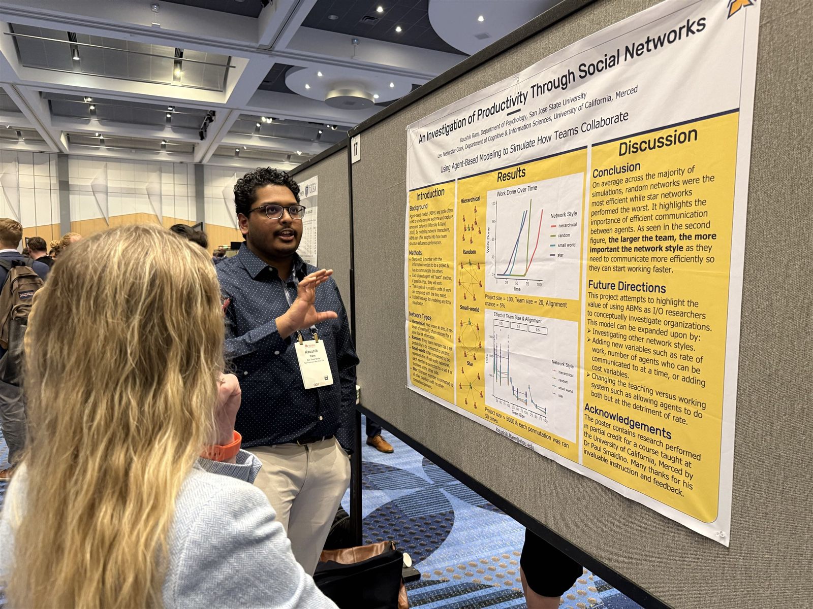 Kaushik Ram discussing his poster with a conference attendee