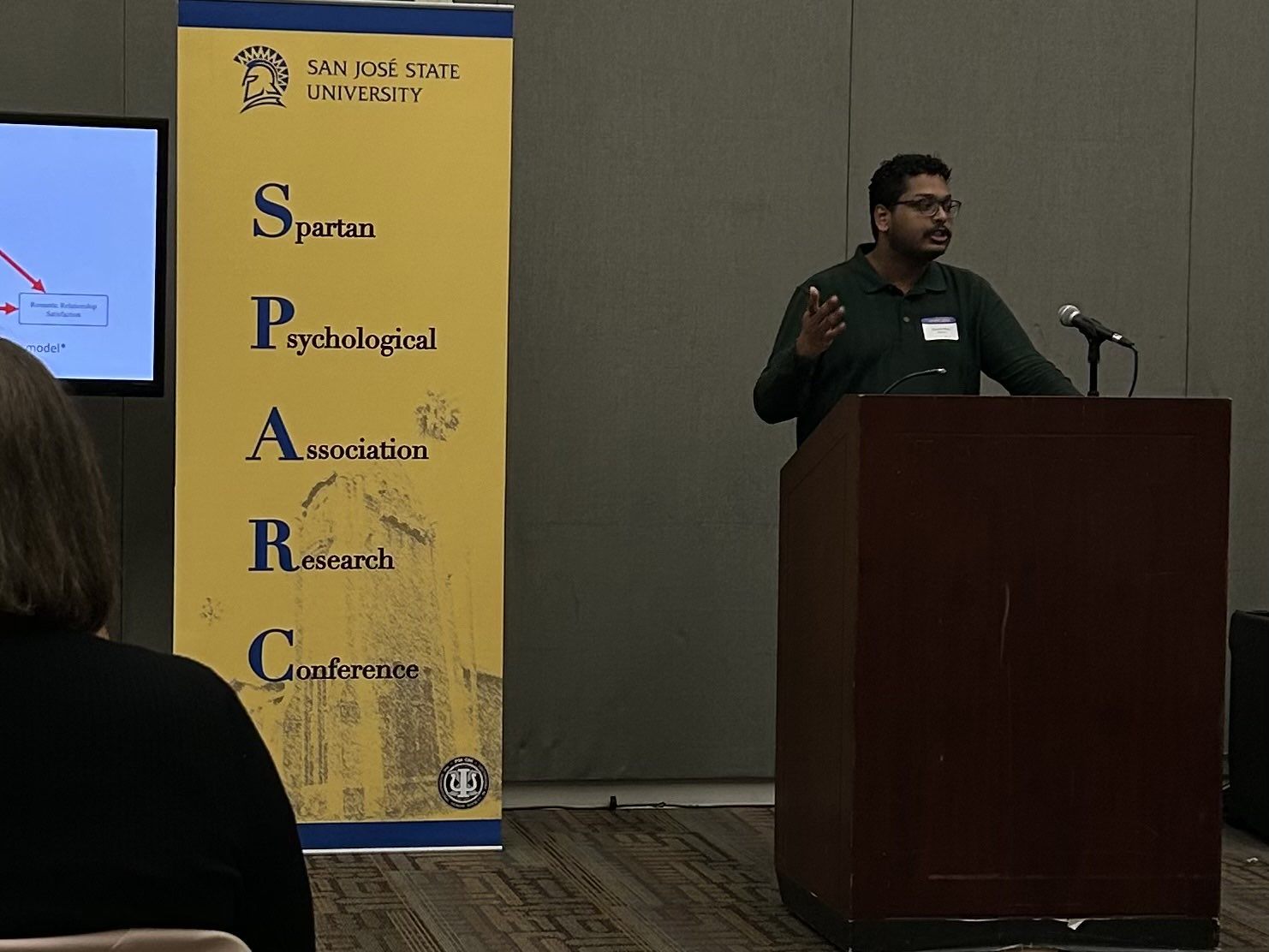 Kaushik Ram speaking at a podium at the Spartan Psychological Association Research Conference